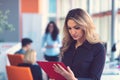 Business woman with folders standing and team mates working in meeting room at office. Royalty Free Stock Photo