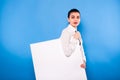 Business woman in formal wear with white panel on blue background Royalty Free Stock Photo