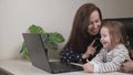 Business woman freelancer works at home with a laptop with a small child, mom types text on a computer keyboard with a Royalty Free Stock Photo