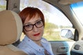 Business woman with glasses sitting on the seat of taxi car and looking at the camera. way to office Royalty Free Stock Photo