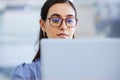 Business woman, glasses and working on laptop in office, agency and startup company. Focus, face and female worker on Royalty Free Stock Photo