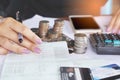 Business woman hand analyzing on account book, with pile of coins , Royalty Free Stock Photo