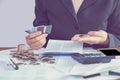 business woman hand calculating her monthly expenses during tax season with coins, calculator, credit card and account bank Royalty Free Stock Photo