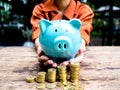 Business woman hand carry blue piggy bank with gold coins pile growth graph, Saving money for future investment plan and Royalty Free Stock Photo