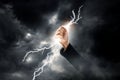 Business woman hand clenching lightning flash