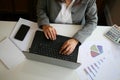 Business woman hand on computer keyboard working with graph reports Royalty Free Stock Photo