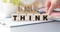 Business woman hand flipping wooden cube blocks with Think text on table background