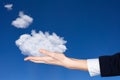Business woman hand hold light white clouds in sky