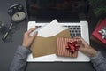 Business woman hand holding christmas card and gift box on desk.