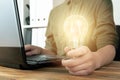 Business woman hand holding lightbulb in office. Concept saving energy, idean and creativity Royalty Free Stock Photo