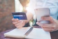 Business woman hand holds a blue credit card and use mobile phones. Royalty Free Stock Photo