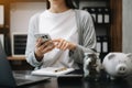 Business woman hand putting money coin into piggy bank with step of growing stack coins for saving money at modern office Royalty Free Stock Photo