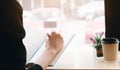 Business woman hand working at a computer and writing on a noteped with a pen in the office