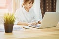 Business woman hand working laptop on wooden desk in office in morning light. Royalty Free Stock Photo