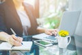 Business woman hand is writing notebook with a pen and using a Royalty Free Stock Photo