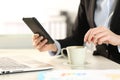 Business woman hands checking phone stirring coffee