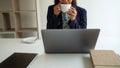 A business woman is having coffee while working on her computer in the office. relaxing from work concept Royalty Free Stock Photo