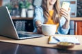 Business woman having a facetime video call. Happy and smiling girl working from home office kithcen and drinking coffee Royalty Free Stock Photo