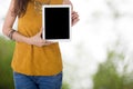 Business woman hold computer tablet with blur tree background Royalty Free Stock Photo