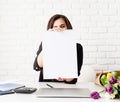 Business woman holding blank wall calendar, working with flowers at the office