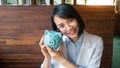 A business woman is holding  a blue piggy bank  close to her face, saving money is an investment for the future. Banking Royalty Free Stock Photo