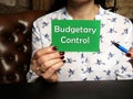 Business Woman holding green business card with written text Budgetary Control - closeup shot
