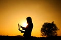 Business woman holding laptop at sunset silhouette. Royalty Free Stock Photo