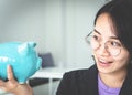 Business woman is holding and looking at piggy bank in hand , girl saving money in happy face saving money for invest for business Royalty Free Stock Photo