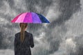 Business woman holding multicolored umbrella under sky with fall Royalty Free Stock Photo