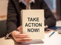 Business woman holding a notebook with the text Take action now