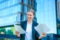 Business woman holding papers in her hands raised up, happy smiling Royalty Free Stock Photo