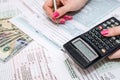 Business woman holding pen and calculator on Tax Form