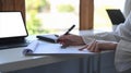 Business woman holding pen and checking reports at office desk. Royalty Free Stock Photo