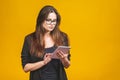 Business woman holding tablet computer isolated against yellow background Royalty Free Stock Photo