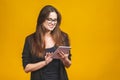 Business woman holding tablet computer isolated against yellow background Royalty Free Stock Photo