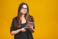 Business woman holding tablet computer isolated against yellow background Royalty Free Stock Photo