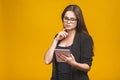 Business woman holding tablet computer isolated against yellow background Royalty Free Stock Photo