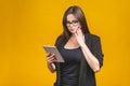 Business woman holding tablet computer isolated against yellow background Royalty Free Stock Photo