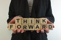 Business woman holding text think forward from wooden blocks Royalty Free Stock Photo