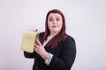 Business woman holding a yellow notepad taking notes