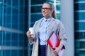 The young business woman holds in her hands folder with documents and cup of coffee. Businesswoman standing next to the business Royalty Free Stock Photo