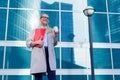 The young business woman holds in her hands folder with documents and cup of coffee. Businesswoman standing next to the business Royalty Free Stock Photo