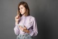 Business woman holds a notebook with a pen. Something writes and thinks. Studio photography. One on a gray background. Royalty Free Stock Photo