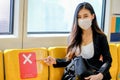 Business woman with hygiene mask point to seat with show banner of prohibit sit near to the other to support social distancing in