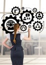 Business woman interacting with people in cogs graphics against office background Royalty Free Stock Photo