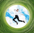 Business woman jumps in rotated field with green grass. Royalty Free Stock Photo
