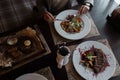 Business woman with a knife and fork eats a vegetable salad from fresh vegetables with fish and poached egg in a cafe. Royalty Free Stock Photo