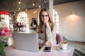 Business woman with laptop and phone in cafe