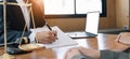 Business woman and lawyers discussing contract papers with brass scale on wooden desk in office. Law, legal services, advice, Royalty Free Stock Photo