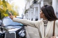 Business woman in London hailing for a black taxi